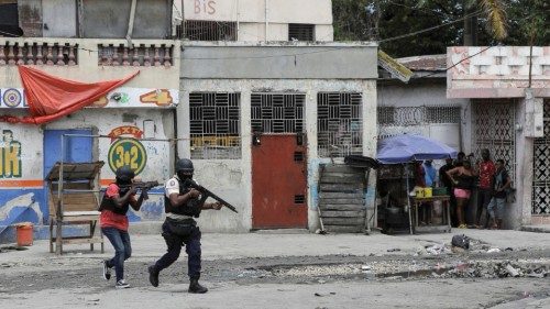 FILE PHOTO: People huddle in a corner as police patrol the streets after gang members tried to ... FILE PHOTO: People huddle in a corner as police patrol the streets after gang members tried to ...