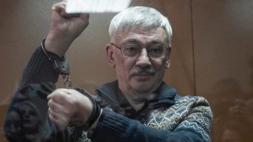 Russian veteran human rights campaigner Oleg Orlov gestures in handcuffs while standing behind a ... Russian veteran human rights campaigner Oleg Orlov gestures in handcuffs while standing behind a ...