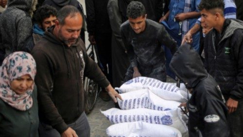 A Palestinian man transports sacks of humanitarian aid at the distribution center of the United ... A Palestinian man transports sacks of humanitarian aid at the distribution center of the United ...
