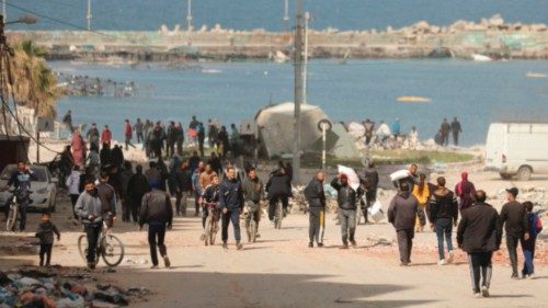 Palestinians run along a street as humanitarian aid arrives in Gaza City on March 6, 2024, amid the ... Palestinians run along a street as humanitarian aid arrives in Gaza City on March 6, 2024, amid the ...