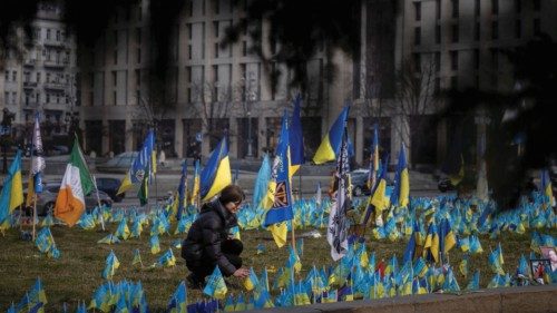 A woman reacts as she sets down a Ukrainian flag in memory a fallen soldier at a memorial site for ... A woman reacts as she sets down a Ukrainian flag in memory a fallen soldier at a memorial site for ...