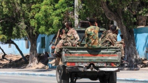 Somalian soldiers drive on the back of a military vehicle in a street near a hotel in Mogadishu on ... Somalian soldiers drive on the back of a military vehicle in a street near a hotel in Mogadishu on ...