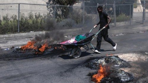 epa11217538 A person pushes a cart past tires set on fire by demonstrators during a protest in ... epa11217538 A person pushes a cart past tires set on fire by demonstrators during a protest in ...