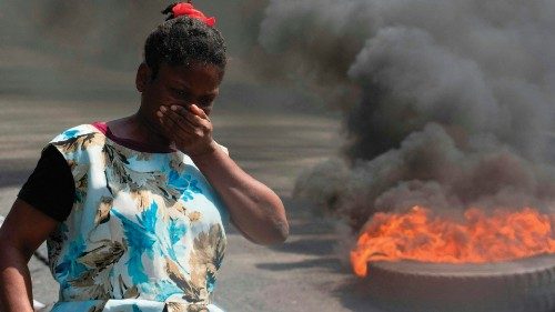 A woman walks past burning tires during a demonstration following the resignation of its Prime ... A woman walks past burning tires during a demonstration following the resignation of its Prime ...
