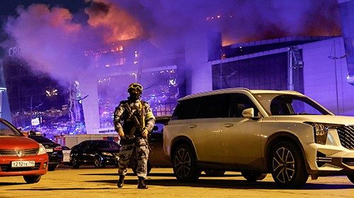 A Russian law enforcement officer walks at a parking area near the burning Crocus City Hall concert ... A Russian law enforcement officer walks at a parking area near the burning Crocus City Hall concert ...