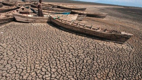 A young Malawian man stands among stationary engineless boats which lie idle at the dried inland ... A young Malawian man stands among stationary engineless boats which lie idle at the dried inland ...