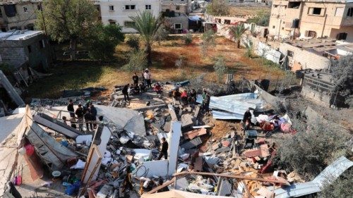 In this aerial view, Palestinians assess the destruction of a house hit by Israeli bombardment in ...