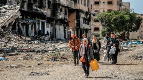 TOPSHOT - A girl walks holding a jerrycan ahead of other displaced people evacuating with ...