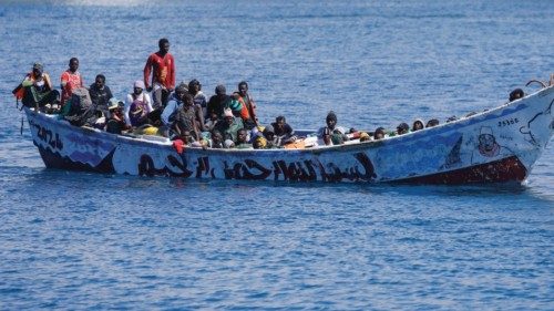 Migrants wait to disembark from a fiber boat in the port of Arguineguin, on the island of Gran ... Migrants wait to disembark from a fiber boat in the port of Arguineguin, on the island of Gran ...