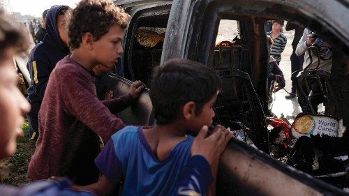 EDITORS NOTE: Graphic content / TOPSHOT - People gather around the carcass of a car used by US-based ...