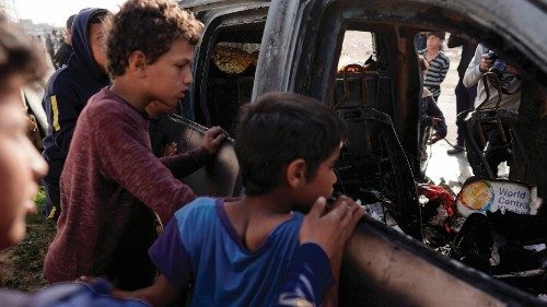 EDITORS NOTE: Graphic content / TOPSHOT - People gather around the carcass of a car used by US-based ... EDITORS NOTE: Graphic content / TOPSHOT - People gather around the carcass of a car used by US-based ...