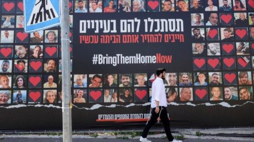 epa11256552 A man walks past a large-scale billboard showing images of Israeli hostages held by ... epa11256552 A man walks past a large-scale billboard showing images of Israeli hostages held by ...