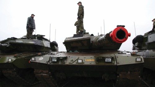 Swedish soldiers stand on top of parked Stridsvagn 122 tanks during training outside Visby on the ... Swedish soldiers stand on top of parked Stridsvagn 122 tanks during training outside Visby on the ...