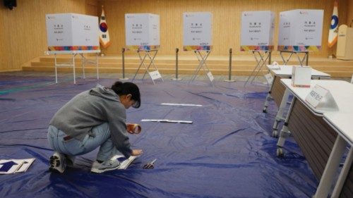 A government official sets up a polling station for the upcoming 22nd parliamentary election at a ...