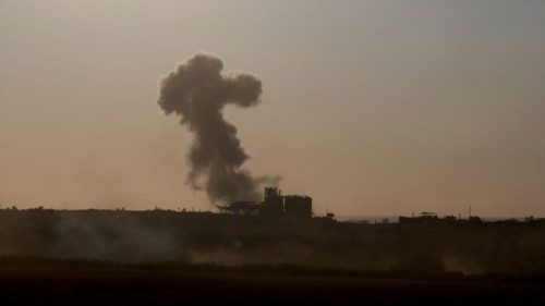Smoke rises in Gaza, as an Israeli tank manoeuvres near the Israel-Gaza border, amid the ongoing ...