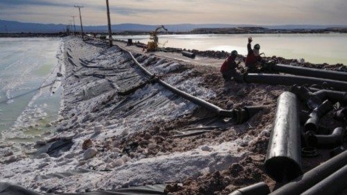 Workers perform maintenance next to pools of brine slowly turning into lithium at the SQM mine in ... Workers perform maintenance next to pools of brine slowly turning into lithium at the SQM mine in ...