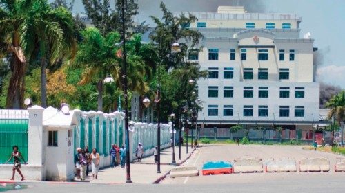 As smoke billows from the Ministry of Finance building behind them, people leave the area after ...