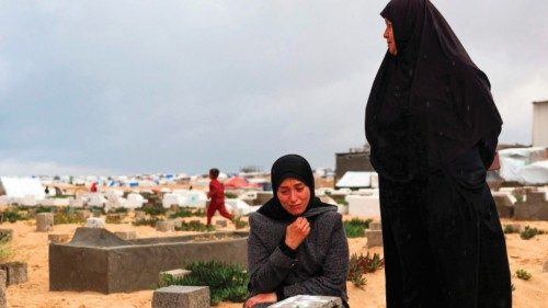 A woman cries over the grave of a loved one at the start of the Eid al-Fitr festival, marking the ...