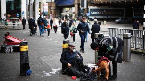 A security guard talks to a homeless person and a dog outside Waterloo Station in London on April ...