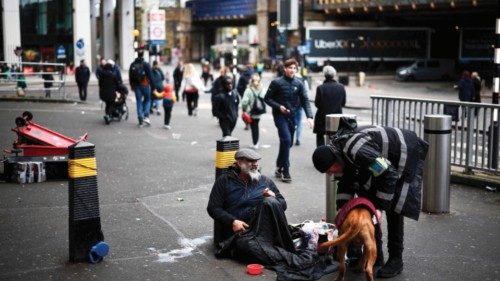 A security guard talks to a homeless person and a dog outside Waterloo Station in London on April ... A security guard talks to a homeless person and a dog outside Waterloo Station in London on April ...