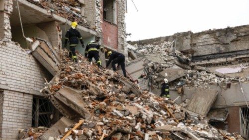 Rescuers work at the site of a destroyed hotel during a Russian missile strike, amid Russia's ...