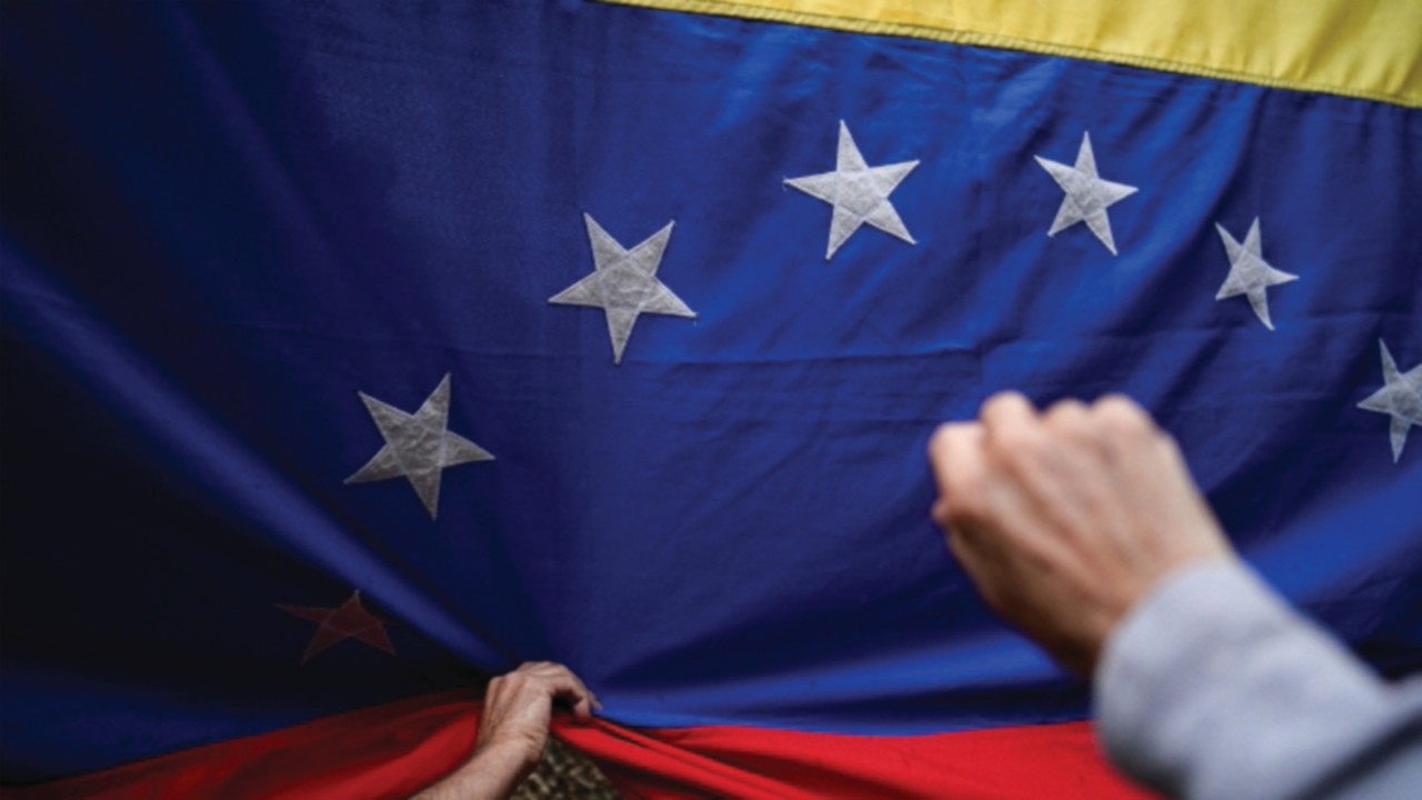Followers of Venezuelan opposition leader Maria Corina Machado hold a national flag during her ...
