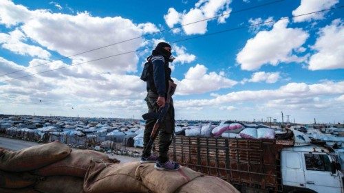 (FILES) A member of Kurdish internal security forces watches as another group of Syrian families is ...