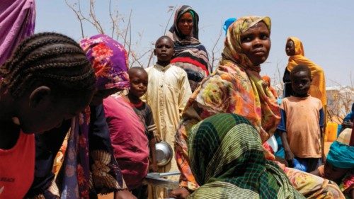 Sudanese refugees gather to fill cans with water from a water point in the Farchana refugee camp, on ...