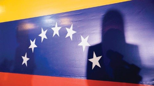 epa10937196 The shadow of former deputy Maria Corina Machado is cast on the Venezuelan flag while ...