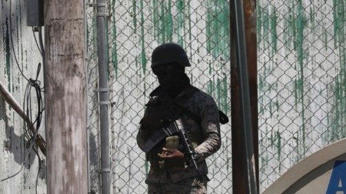 A Haitian soldier stands guard outside the international airport after a U.S. plane landed, in ...