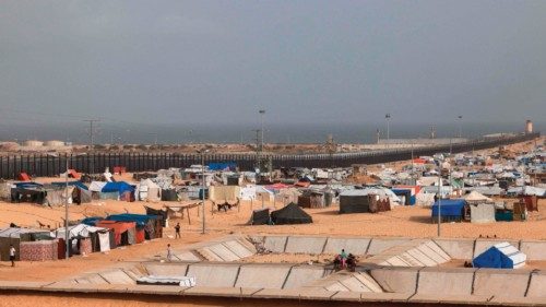 Displaced Palestinians walk near tents at a camp in Rafah in the southern Gaza Strip near the border ...