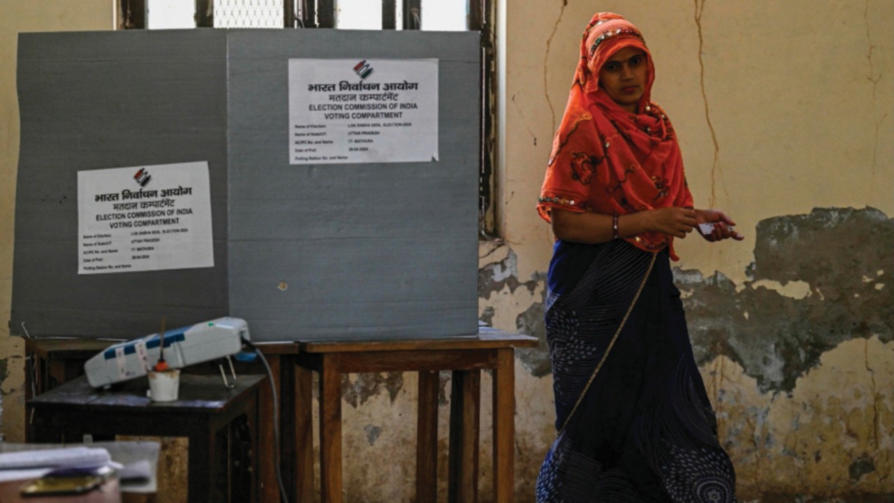 A woman walks after casting her ballot at a polling station during the second phase of voting of an ...
