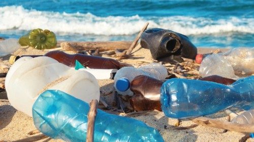 Spilled garbage on the beach of the big city. Empty used dirty plastic bottles. Empty used dirty ...