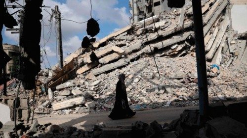 TOPSHOT - A Palestinian woman walks past the rubble of buildings destroyed in previous Israeli ... TOPSHOT - A Palestinian woman walks past the rubble of buildings destroyed in previous Israeli ...