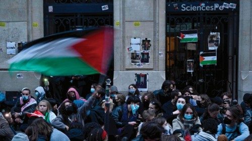 TOPSHOT - A protestor waves a Palestinian flag as they stage a sit-in in front of French riot ... TOPSHOT - A protestor waves a Palestinian flag as they stage a sit-in in front of French riot ...