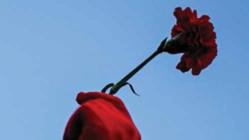 Revelers wearing red gloves hold red carnations as they take part during the 25th April ... Revelers wearing red gloves hold red carnations as they take part during the 25th April ...