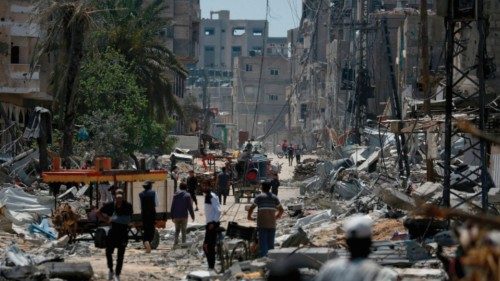 EDITORS NOTE: Graphic content / Palestinians walk amid the rubble of destroyed buildings in ... EDITORS NOTE: Graphic content / Palestinians walk amid the rubble of destroyed buildings in ...