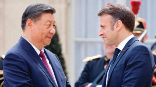 France's President Emmanuel Macron (R) shakes hands with Chinese President Xi Jinping upon his ...