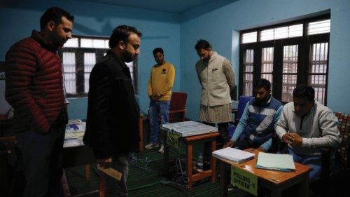 Polling officers check an EVM machine inside a polling station before the voting begins, during the ... Polling officers check an EVM machine inside a polling station before the voting begins, during the ...