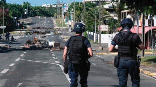 TOPSHOT - Police patrol a street blocked by debris and burnt out items following overnight unrest in ... TOPSHOT - Police patrol a street blocked by debris and burnt out items following overnight unrest in ...