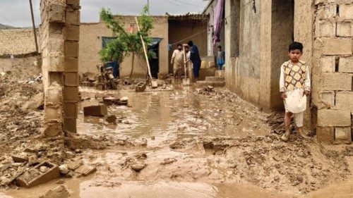 A boy looks on as people remove mud from the courtyard of their houses after floods in Maymana, the ... A boy looks on as people remove mud from the courtyard of their houses after floods in Maymana, the ...
