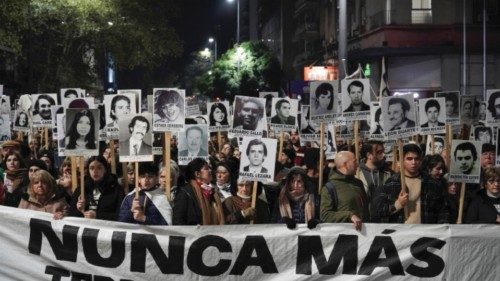 People hold a sign that says 'never again' along with portraits of those who disappeared during the ... People hold a sign that says 'never again' along with portraits of those who disappeared during the ...