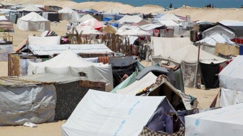 Displaced Palestinians, who fled their house due to Israeli strikes, shelter at a tent camp, amid ... Displaced Palestinians, who fled their house due to Israeli strikes, shelter at a tent camp, amid ...