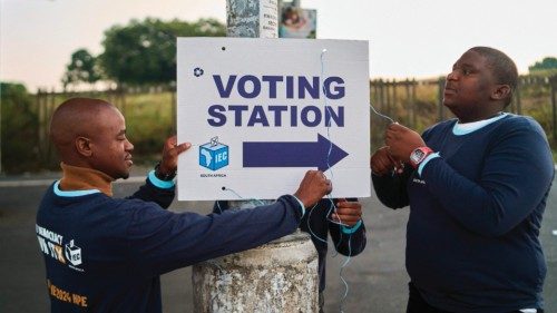 Electoral Commission of South Africa (IEC) officials put up a sign outside a polling station in ...