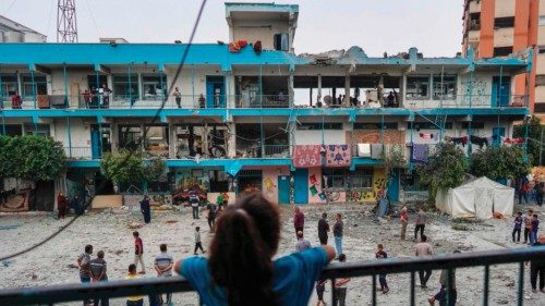 TOPSHOT - A Palestinian girl watches as others check a UN-school housing displaced people that was ... TOPSHOT - A Palestinian girl watches as others check a UN-school housing displaced people that was ...