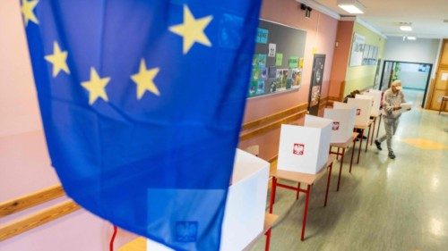 A flag of the European Union is seen in the foreground as a man prepares to cast his ballot for ... A flag of the European Union is seen in the foreground as a man prepares to cast his ballot for ...