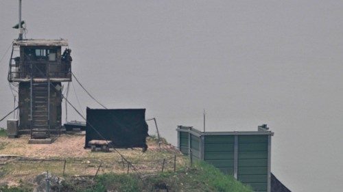 A South Korean soldier stands guard near a military facility (R, green box) where loudspeakers ...