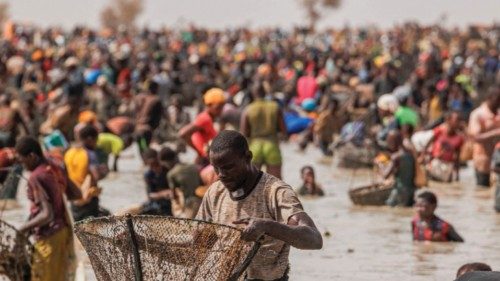 TOPSHOT - A young man checks his fishing net during the Sanke mon collective fishing rite in San, ...