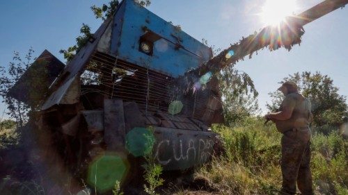 A Ukrainian serviceman of the 22nd Separate Mechanised Brigade stands next to a Russian T-62 Soviet ...