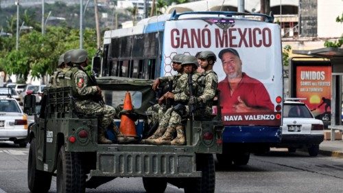 TOPSHOT - Mexican army infantry soldiers aboard military trucks patrol the streets in the tourist ... TOPSHOT - Mexican army infantry soldiers aboard military trucks patrol the streets in the tourist ...